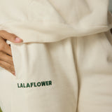OFF-WHITE SWEATPANTS WITH GREEN EMBROIDERY